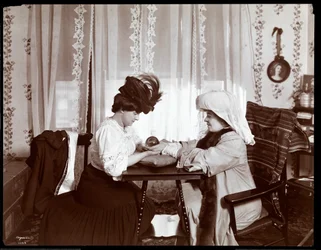 Mrs. Leslie Carter sitzt mit einer Frau, die eine Kristallkugel liest, 1904